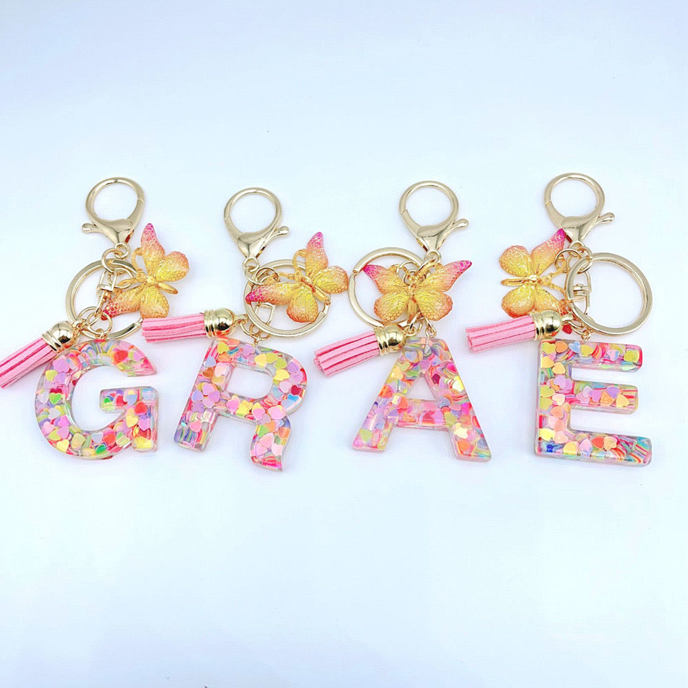 Pink glitter resin initial keychains with gold butterfly charm and tassel – cute personalized gift