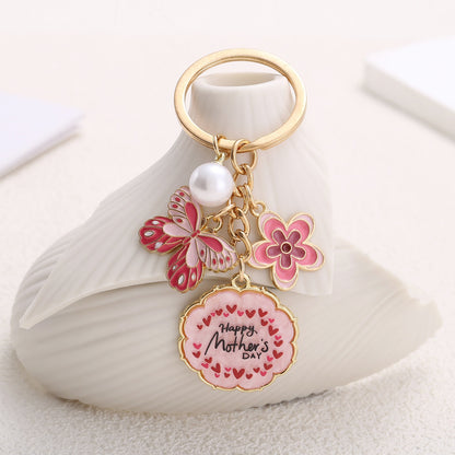 Mother’s Day floral keychain with butterfly, pink flower, and pearl charm – gold-tone design