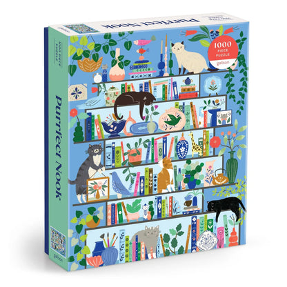 Purrfect Nook 1000-piece puzzle by Galison featuring illustrated cats lounging on colorful bookshelves filled with books, plants, and decorative objects.